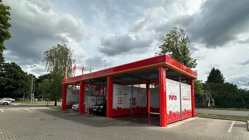 Самообслуживаемая автомойка PUTO с красно-белым дизайном и двумя зонами мойки.