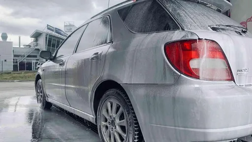 Auto tiek mazgāts ar putām PUTO pašapkalpošanās automazgātavā, uzsverot mazgāšanas priekšrocības.