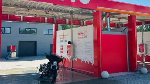 PUTO automazgātava Rūjienā ar motociklu stāvvietā, sarkanbaltā apdarē.