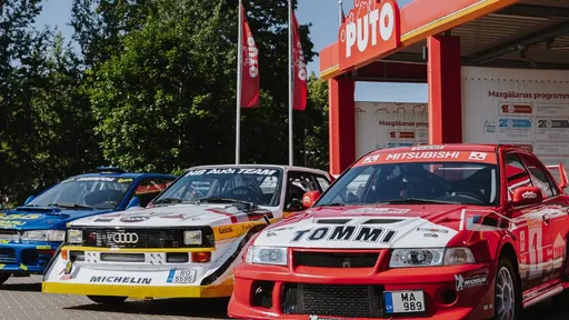 Три спортивных автомобиля возле автомойки PUTO – модели Mitsubishi, Audi и BMW.
