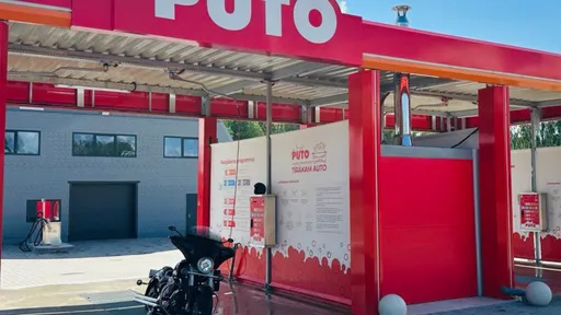 PUTO car wash in Rūjiena with a motorcycle in the bay, featuring red and white decor.
