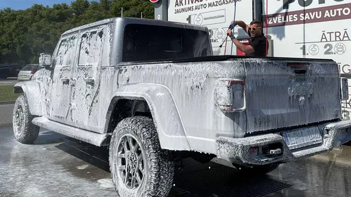 Pickup truck being washed with foam at PUTO self-service car wash.