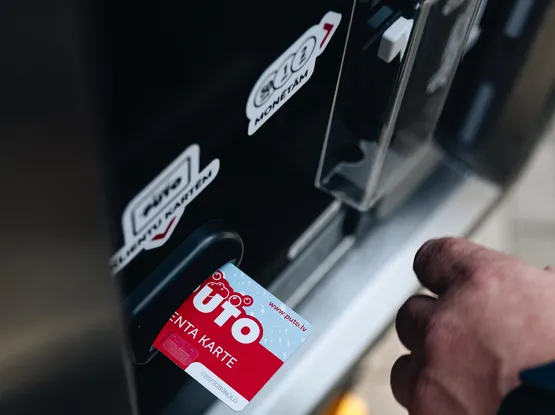 Kartes ievietošana automātiskajā maksājumu terminālī pie automazgātavas.
