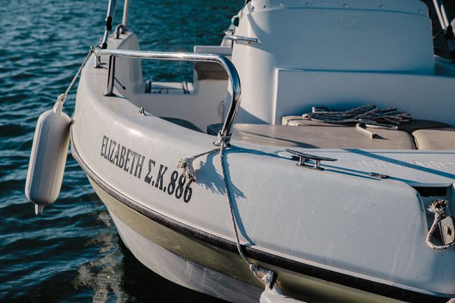 Белый моторный катер на воде с женским именем «Elizabeth» на корпусе.