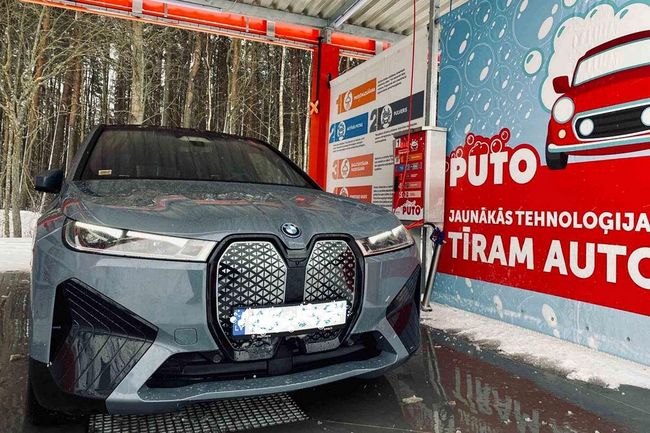 Electric car being washed at PUTO self-service car wash, using active foam technologies.