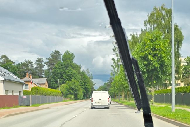 Skats caur automašīnas vējstiklu uz ceļu - vējstikla slotiņas pārbaude pirms vasaras brauciena