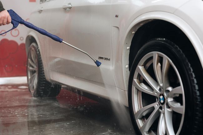 Balts auto tiek mazgāts ar augstspiediena strūklu.