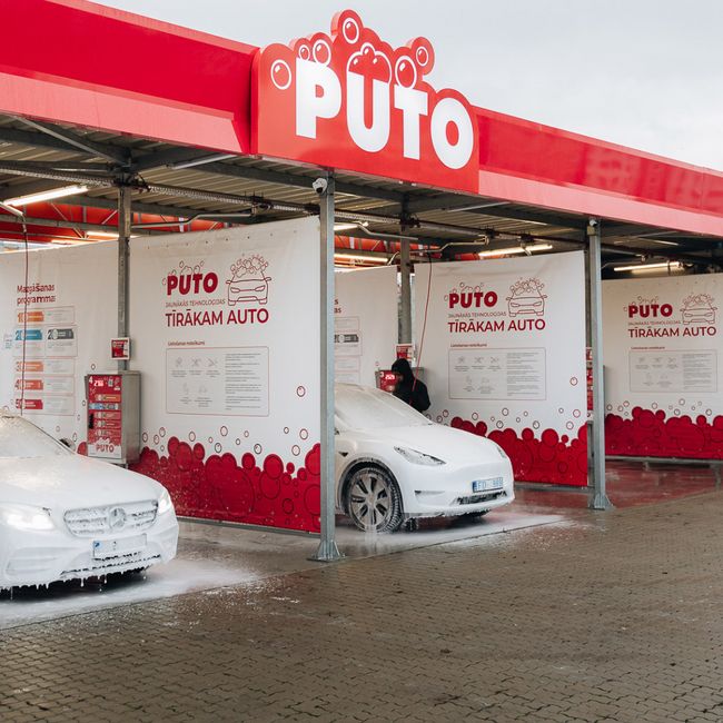 Two cars are being washed with foam at the PUTO car wash