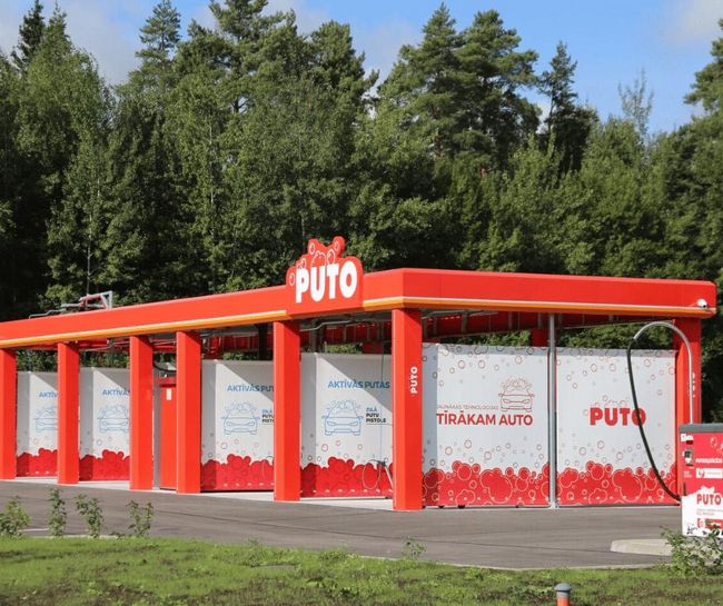 PUTO self-service car wash in Valmiera with a red and white design near the forest.