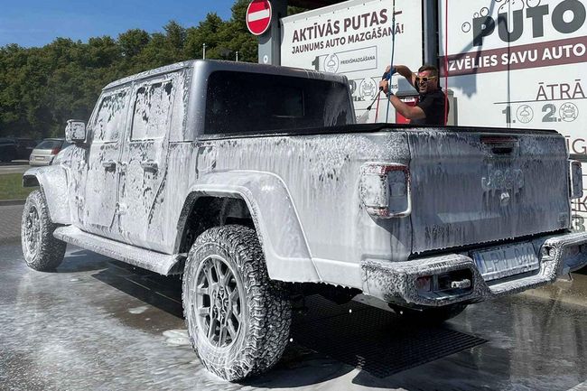 Pickup truck being washed with foam at PUTO self-service car wash.