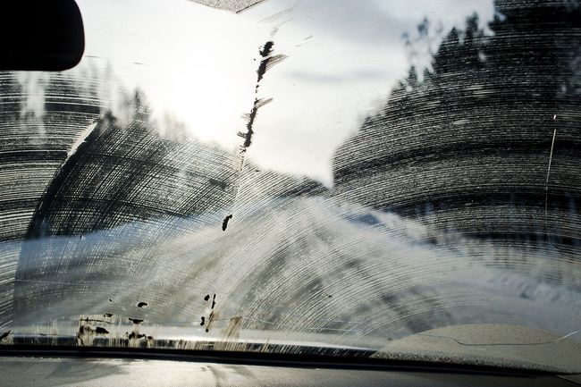 Dirty windshield with wiper marks and reduced visibility while driving