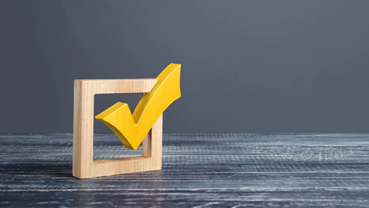 Dzeltena atzīme lodziņā, simbolizējot apstiprinājumu vai izvēli uz pelēka fona.