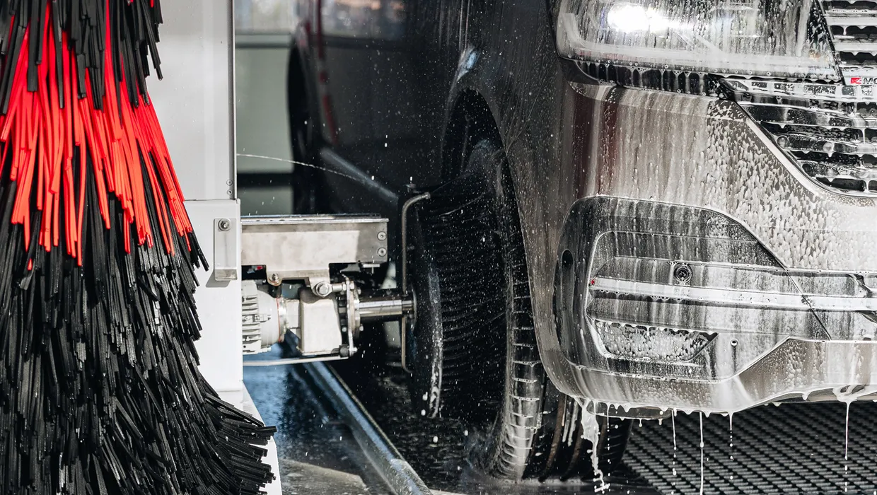 Auto mazgāšana ar putām, blakus divkrāsainas birstes.