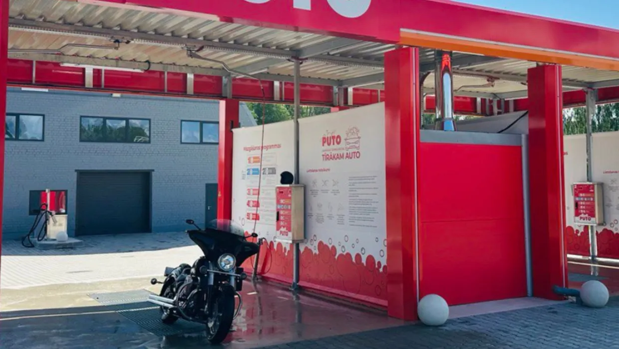 PUTO automazgātava Rūjienā ar motociklu stāvvietā, sarkanbaltā apdarē.