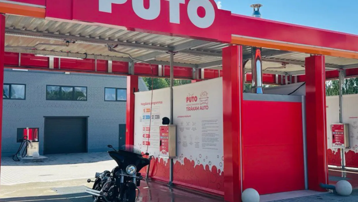 PUTO car wash in Rūjiena with a motorcycle in the bay, featuring red and white decor.