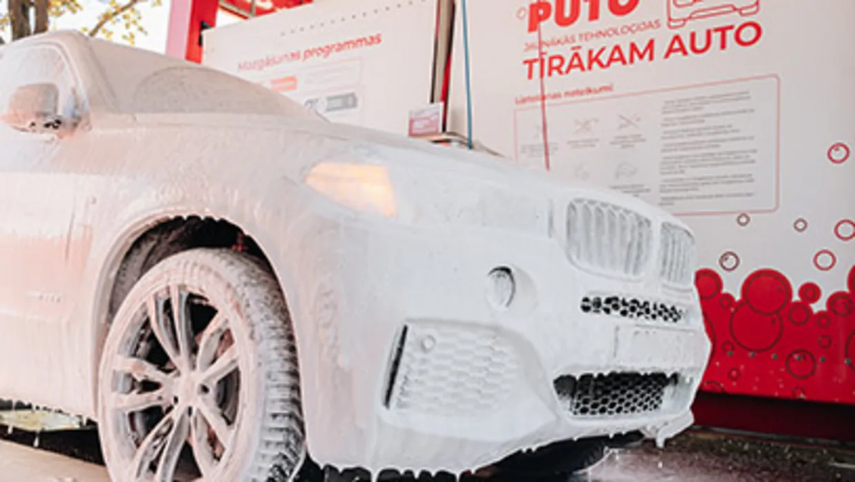 Ar putām pārklāta SUV automašīna pašapkalpošanās automazgātavā